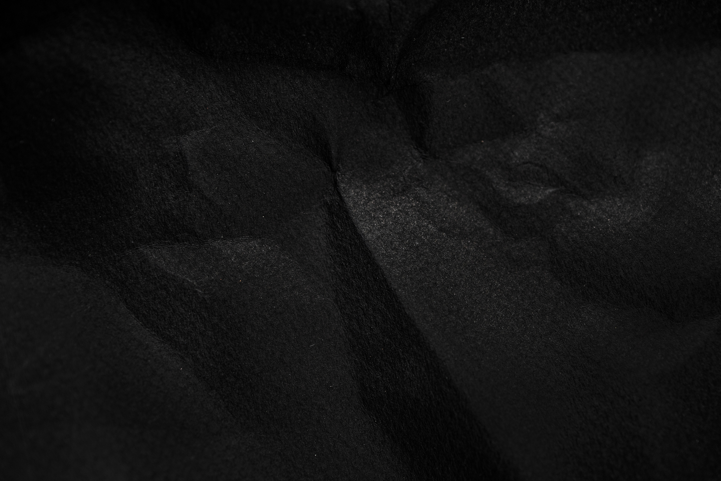 black wrinkled paper texture  background. Crumpled black paper surface